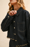 Denim jacket with scalloped hem on a beige background