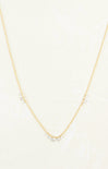 Gold necklace with small pearls on a light beige background