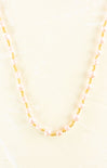 Necklace with pink beads and gold accents on a light yellow background