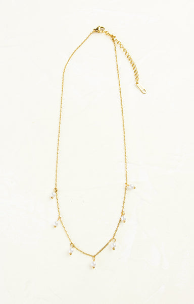 Gold necklace with small beads on a white background