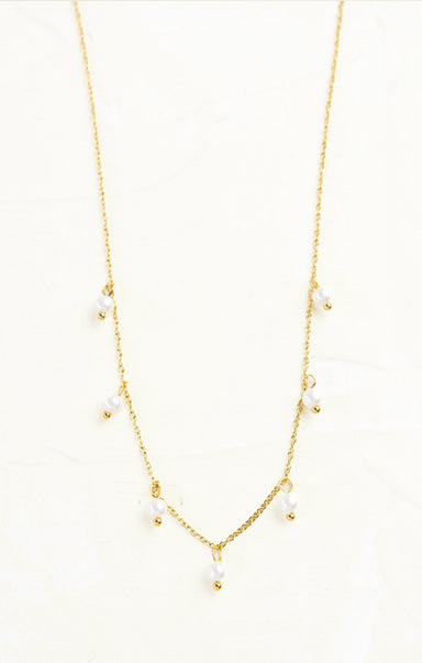 Gold necklace with small pearls on a white background