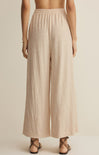 Beige wide-leg pants worn by a person on a beige background