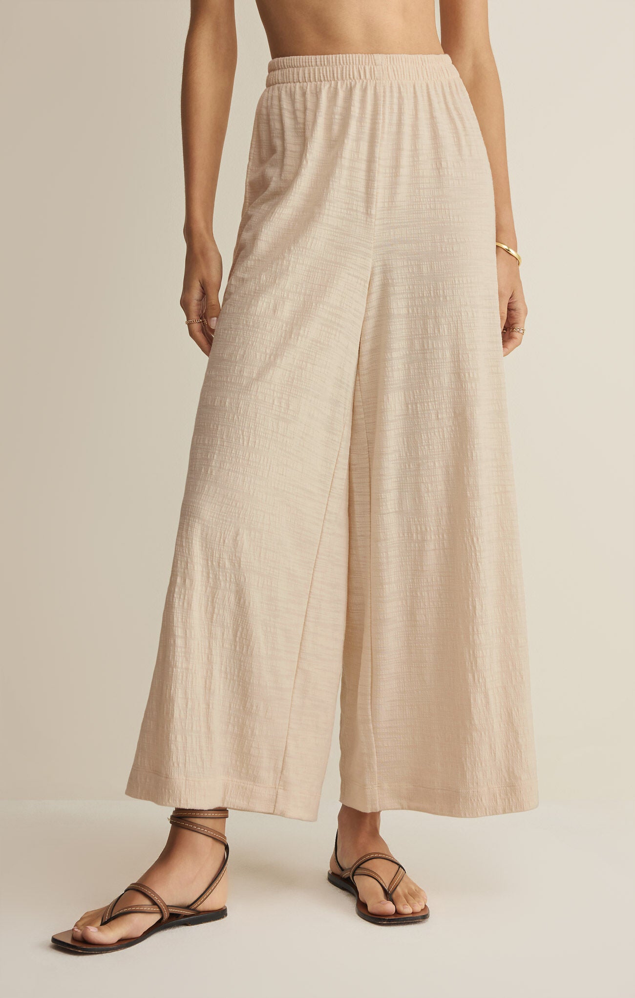 Beige wide-leg pants worn by a person on a plain background