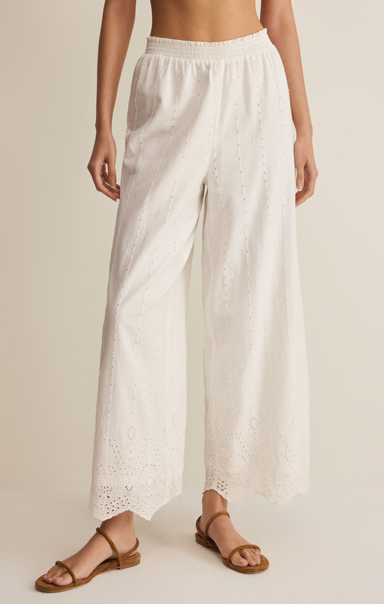 White wide-leg pants worn by a person on a beige background