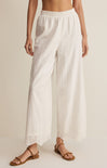 White wide-leg pants worn by a person on a beige background