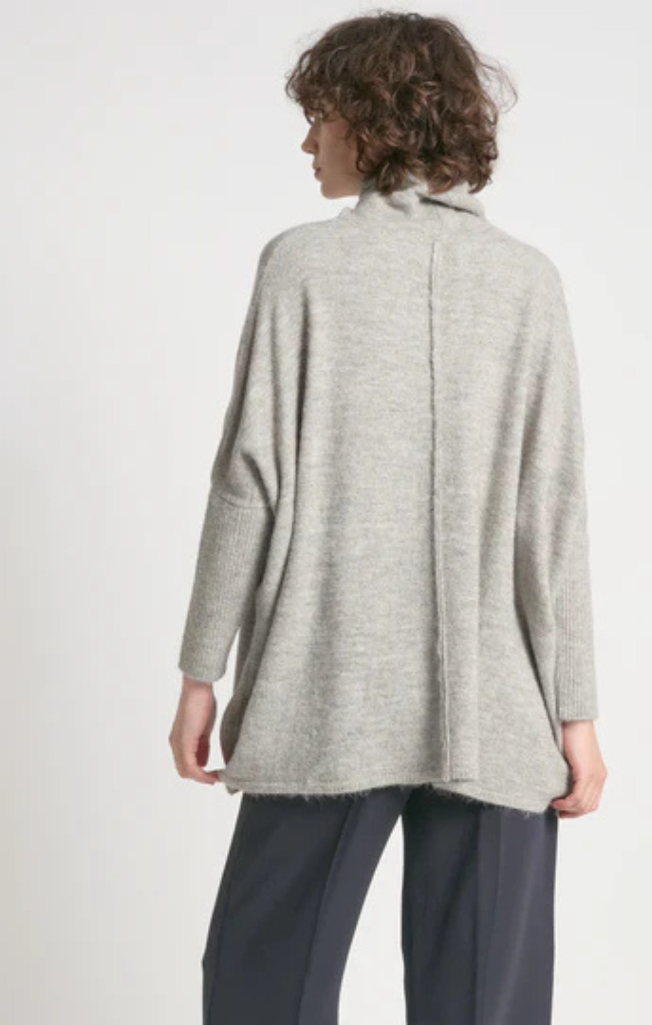 Person wearing a light gray textured cardigan on a white background