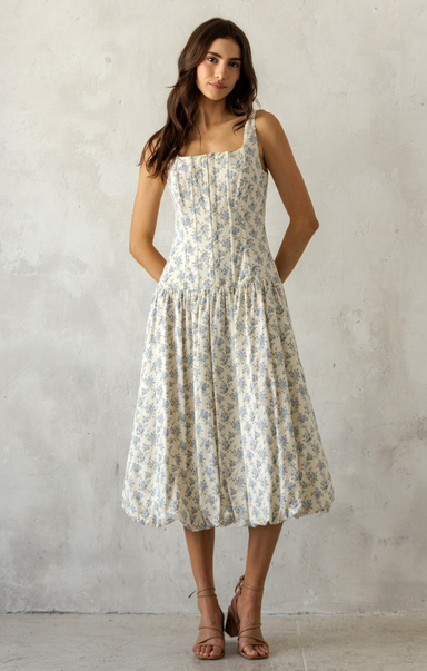 Woman wearing a floral dress against a plain background