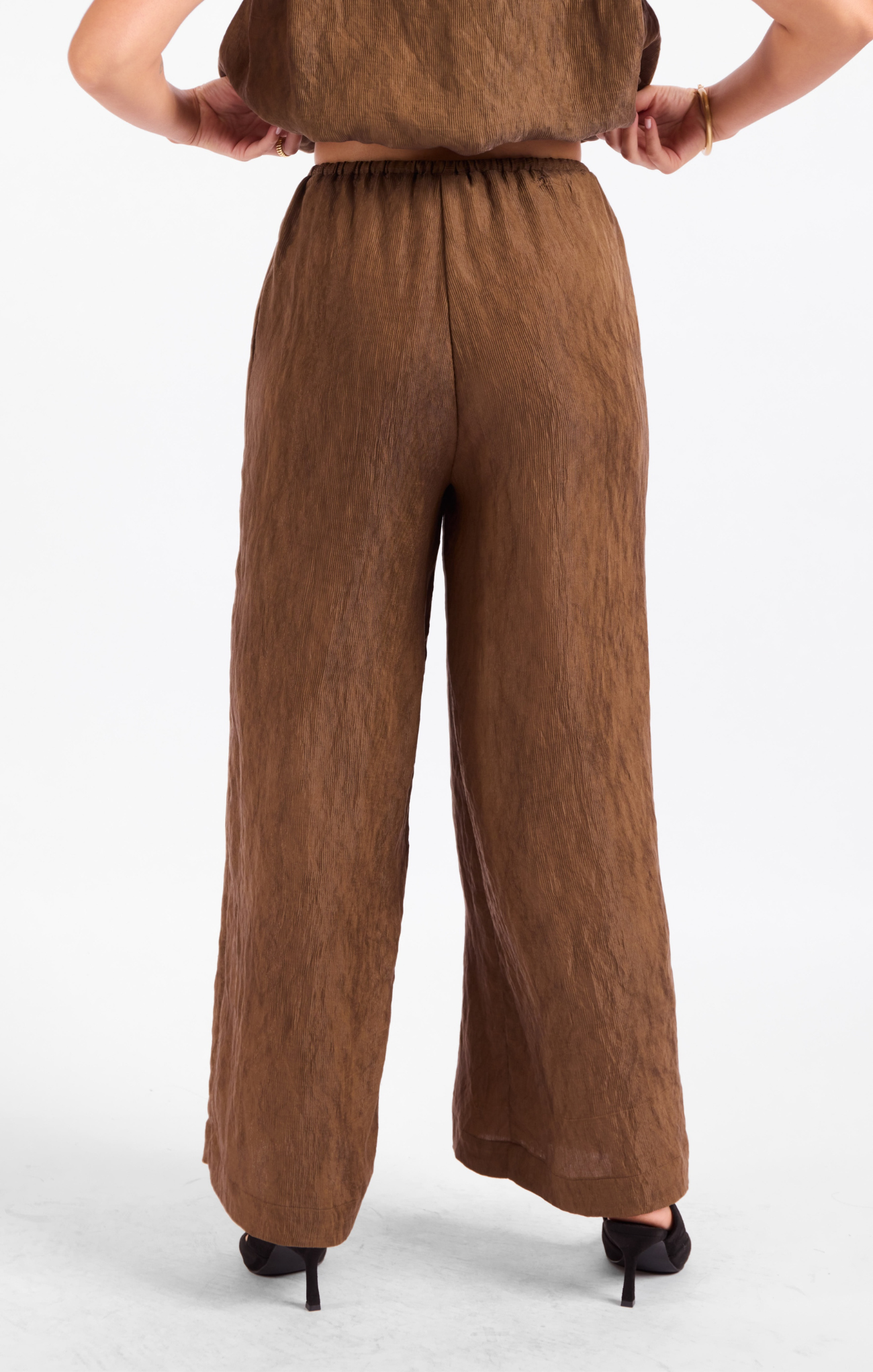 Brown pants worn by a person on a white background