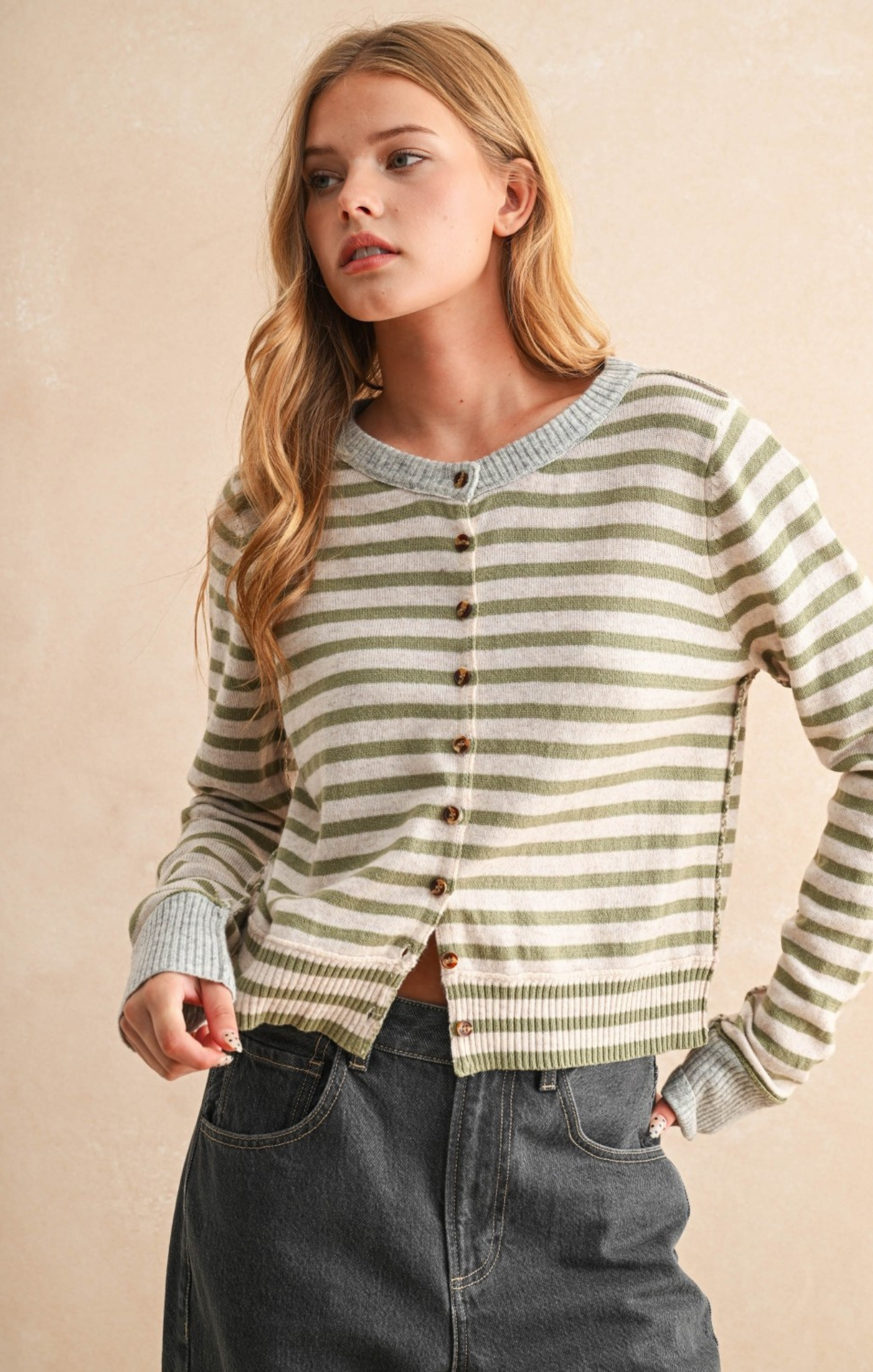 Woman wearing a striped sweater with a beige background