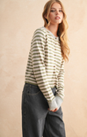 Woman wearing a striped sweater and jeans against a beige background