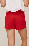 Red shorts worn by a person on a beige background