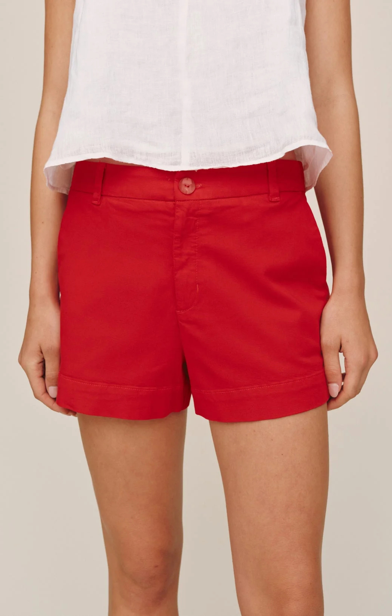 Red shorts worn by a person on a plain background