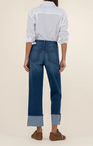 Person wearing blue jeans and a white shirt on a beige background