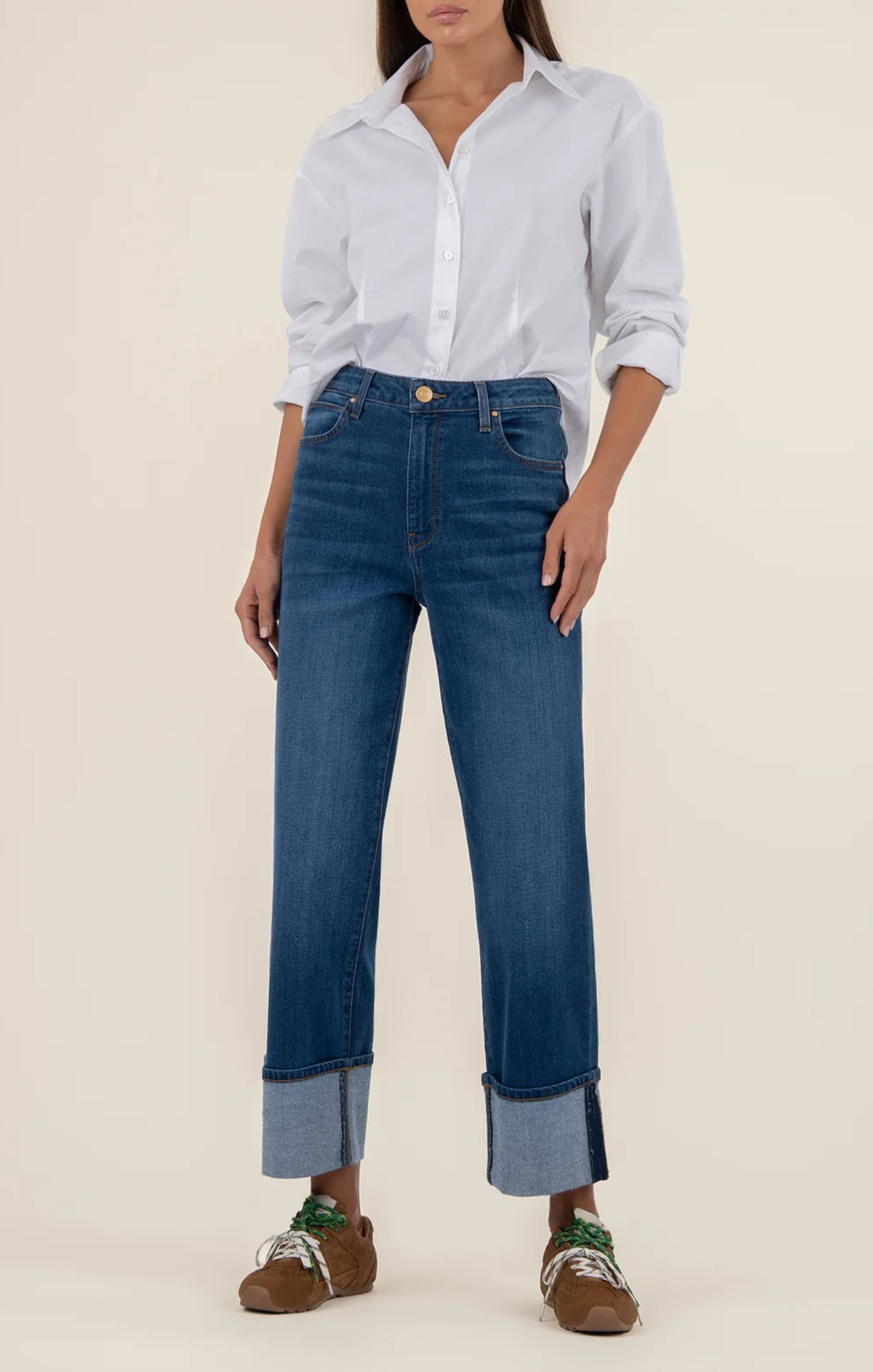 Person wearing a light blue shirt and dark blue jeans on a beige background