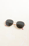 Round sunglasses with gold frame and black lenses on a white background