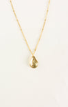Gold necklace with a teardrop pendant on a light beige background