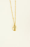 Gold necklace with a teardrop pendant on a beige background