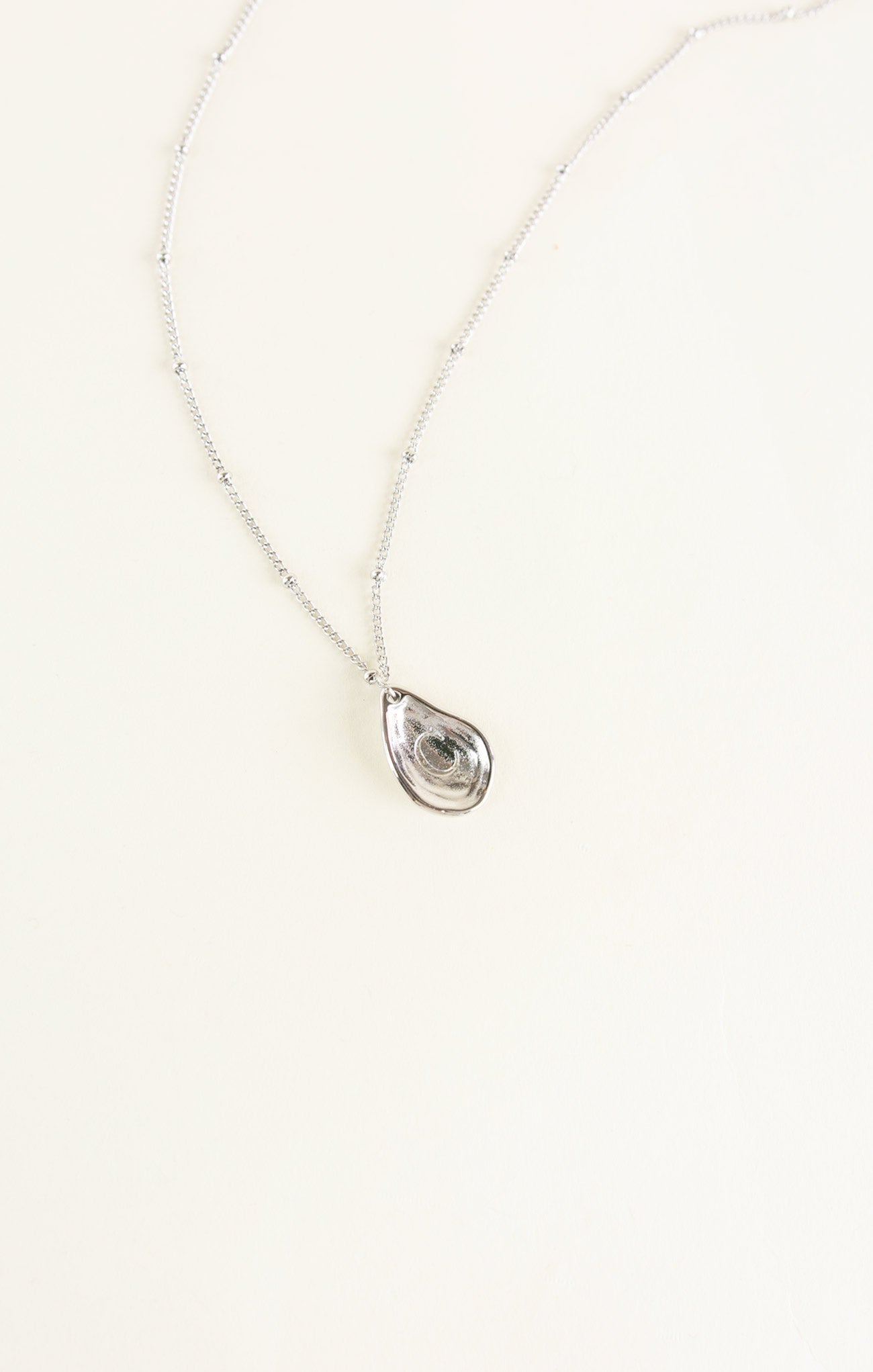 Teardrop-shaped pendant necklace on a white background