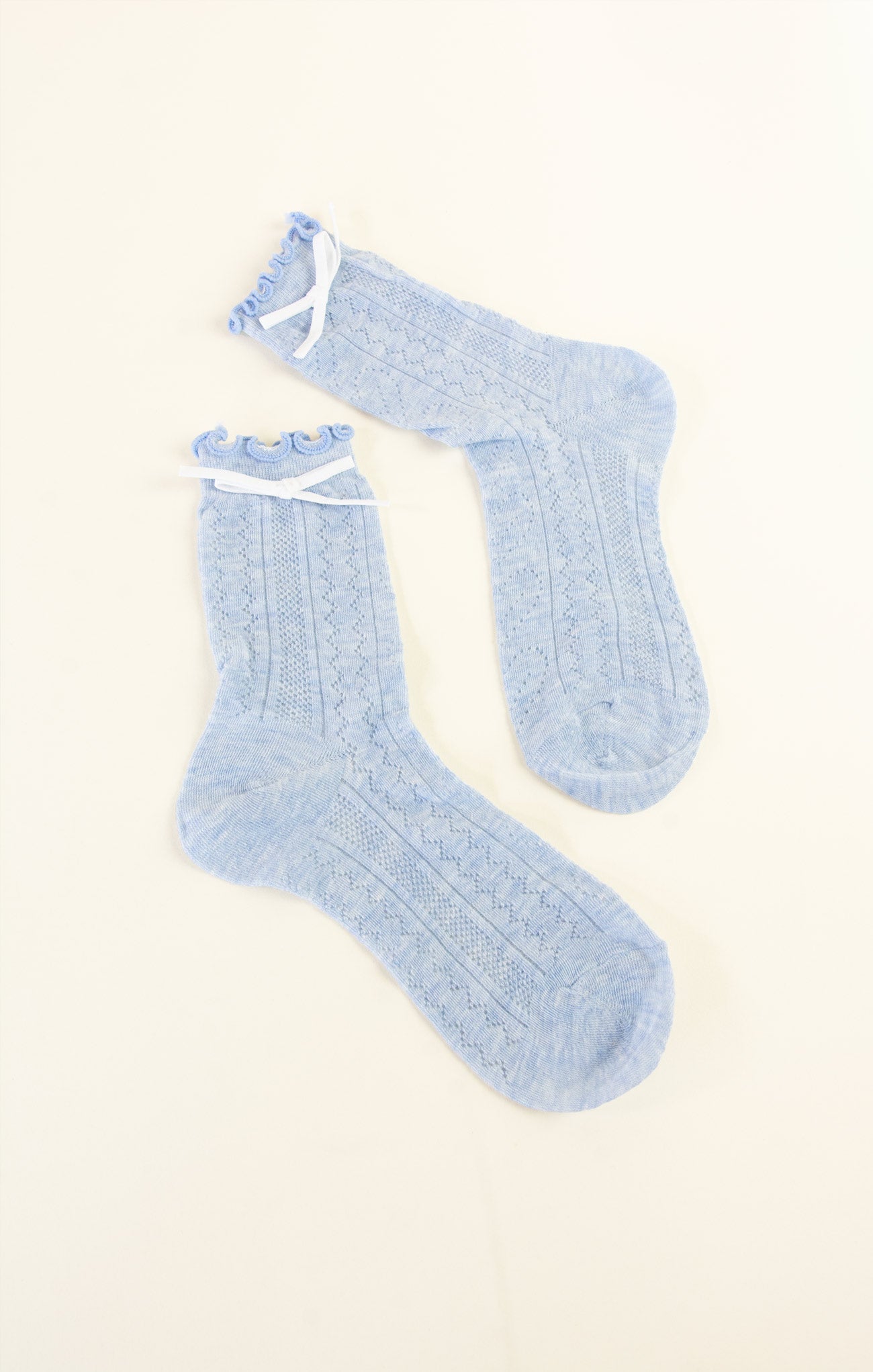 Pair of light blue socks on a beige background