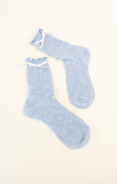 Pair of light blue socks on a beige background