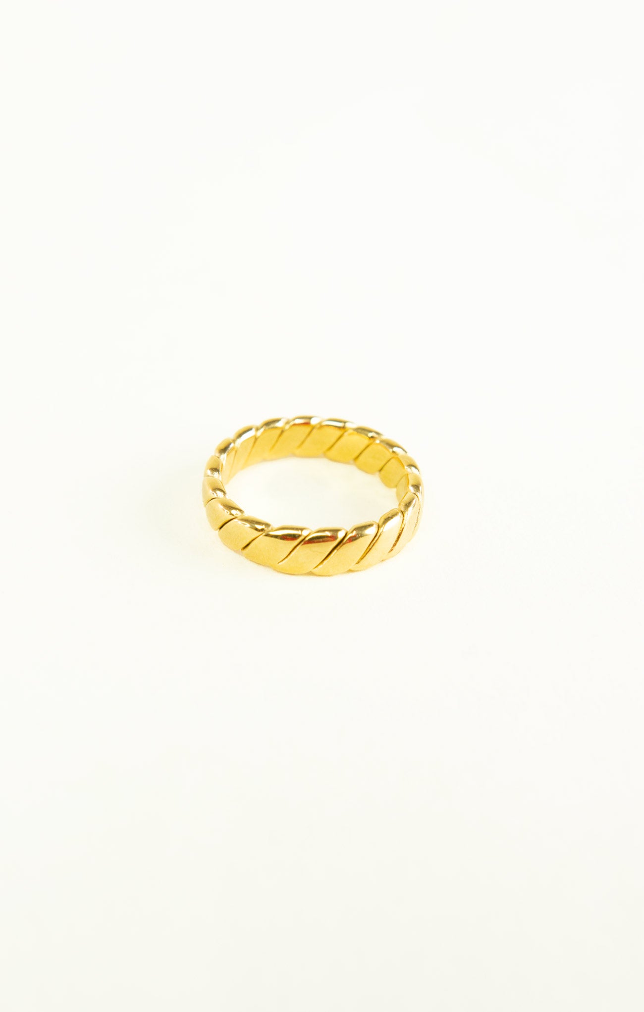Gold ring with a textured design on a white background
