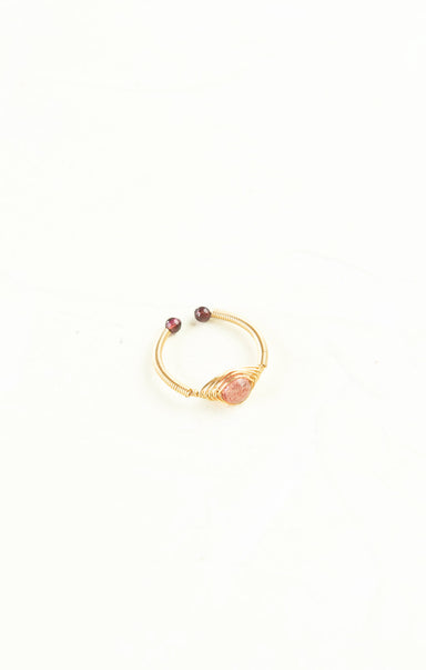 Gold bracelet with pink stones on a white background