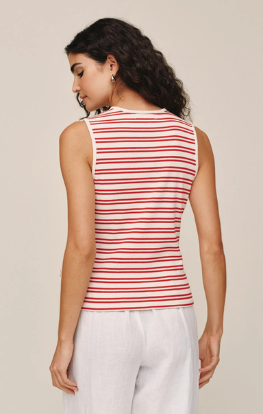 Woman wearing a red and white striped sleeveless top against a beige background