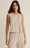 Woman wearing a beige and white striped sleeveless top and pants on a beige background