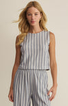 Woman wearing a sleeveless striped top and pants on a beige background