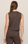 Woman wearing a brown sleeveless top and pants on a beige background