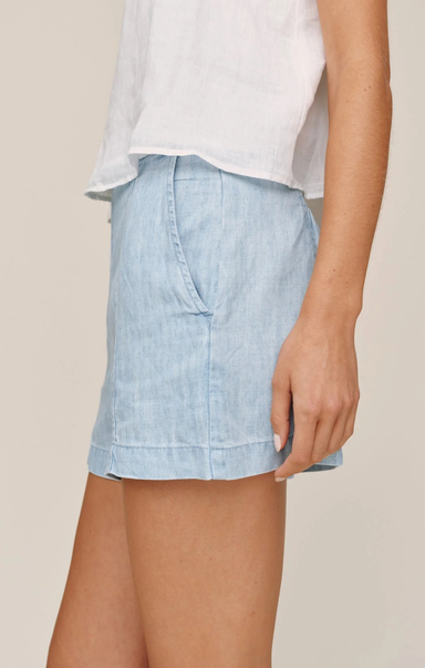 Light blue denim skirt worn by a person on a beige background