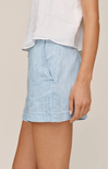 Light blue denim skirt worn by a person on a beige background