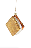 Decorative Christmas ornament shaped like a marshmallow with gold and brown glitter on a white background