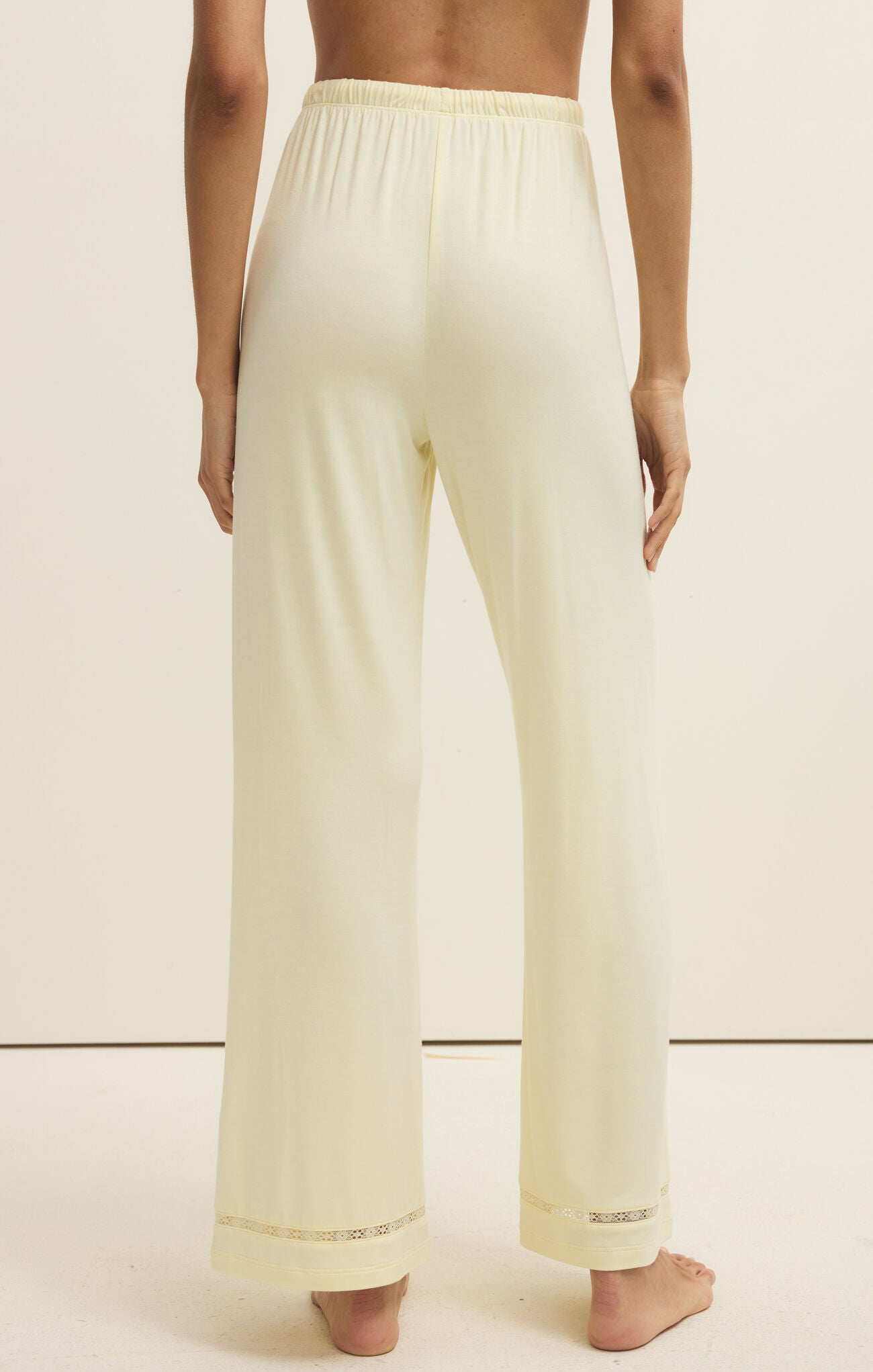Light-colored pants worn by a person on a plain background