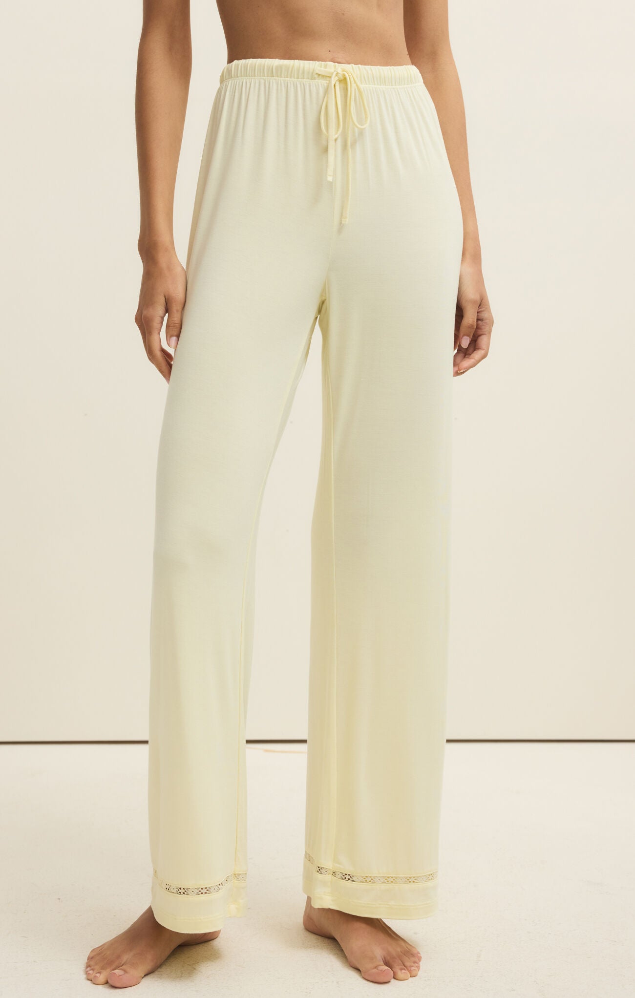 Light yellow pants worn by a person on a beige background