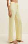Light yellow pants worn by a person on a beige background