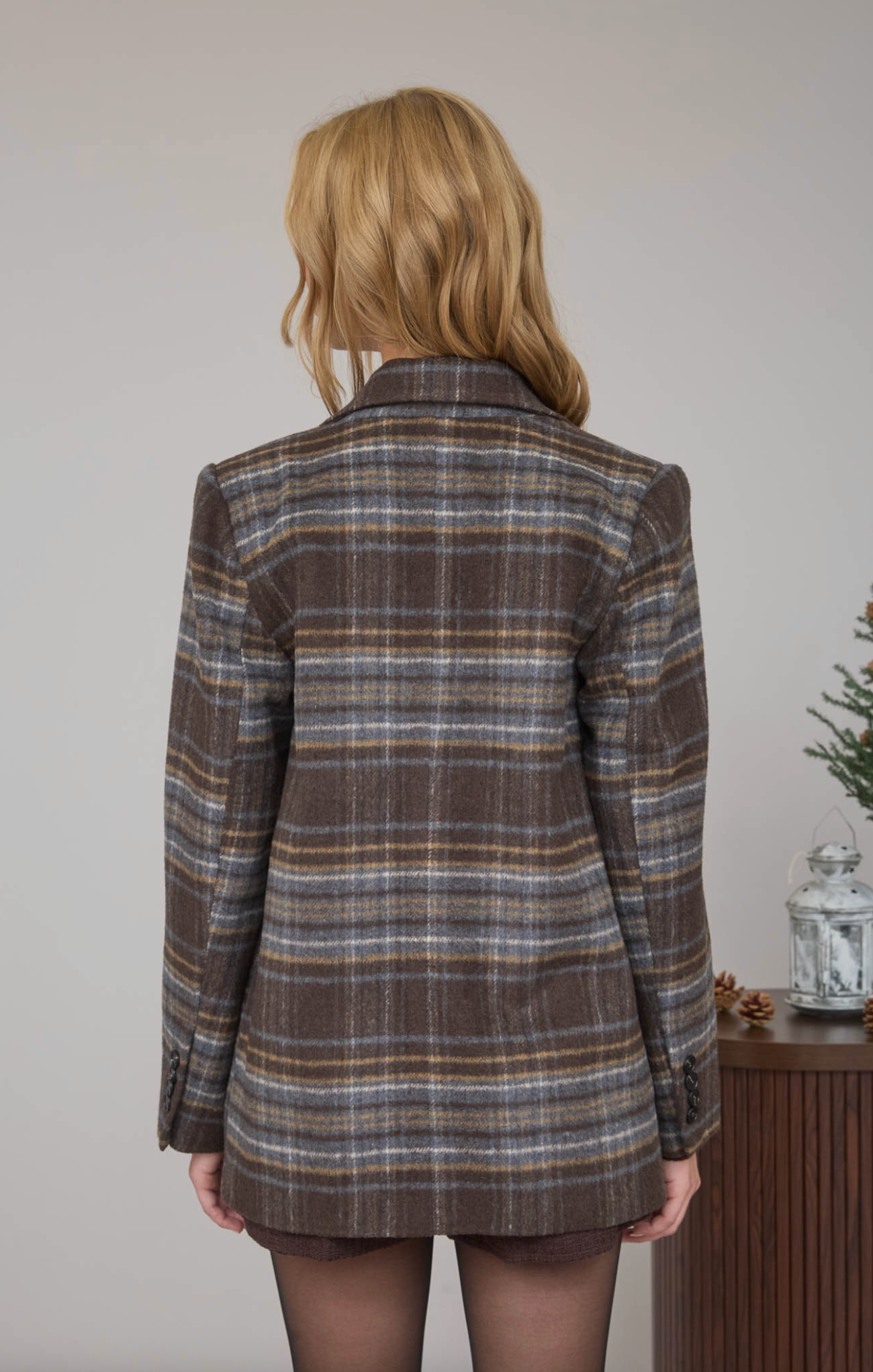 Person wearing a plaid jacket with a neutral background