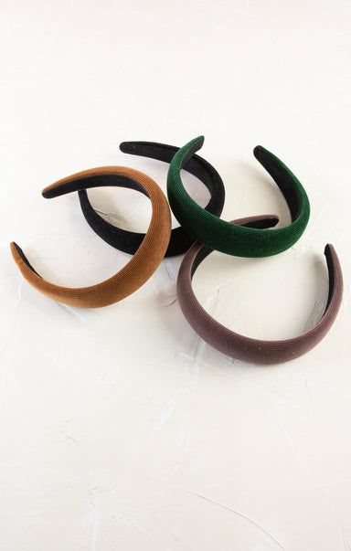 Four headbands in brown, black, green, and purple on a white background