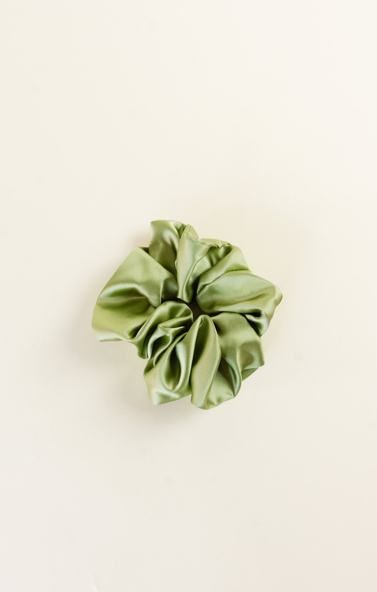 Green scrunchie on a beige background