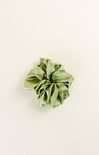 Green scrunchie on a beige background