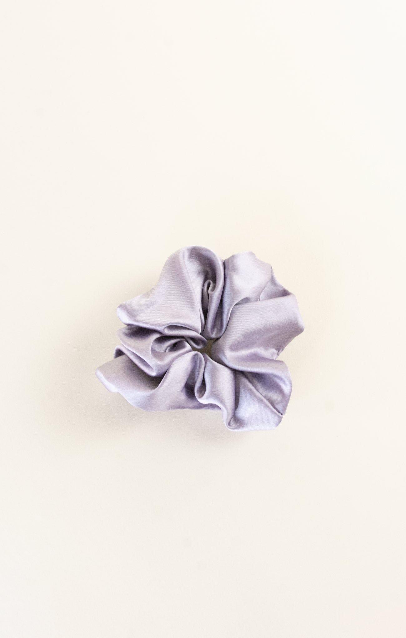 Silver scrunchie on a beige background
