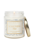 Candle in a jar labeled 'Something Blue' with a decorative label on a white background