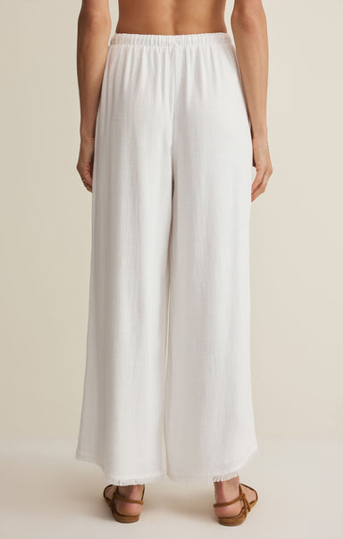 White wide-leg pants worn by a person on a beige background