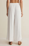 White wide-leg pants worn by a person on a beige background