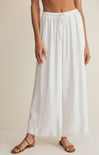 Person wearing a white wide-leg pants on a beige background