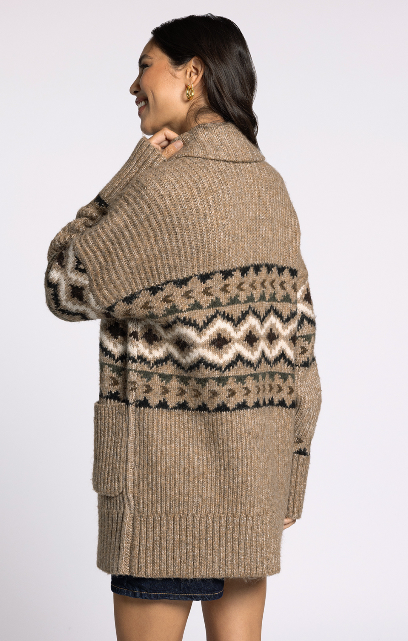 Woman wearing a patterned beige cardigan on a white background