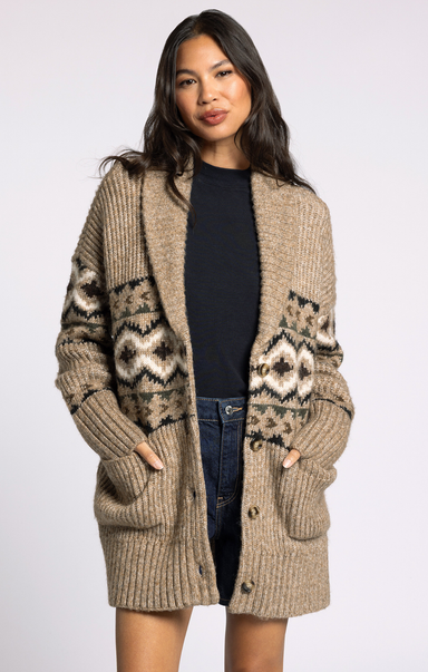 Woman wearing a beige knitted cardigan with patterned sleeves on a white background