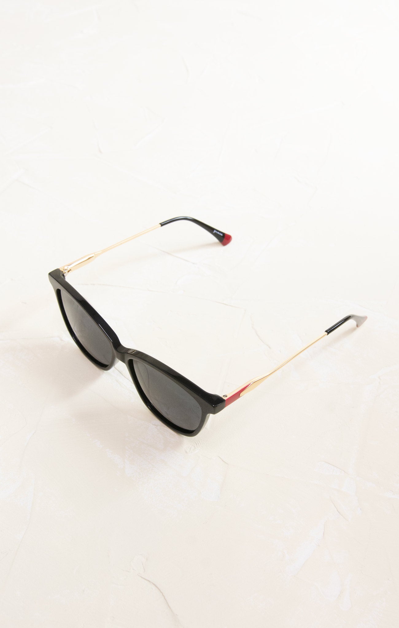 Sunglasses with gold and red frame on a white background
