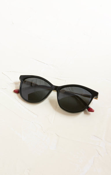 Black sunglasses with red accents on a white background
