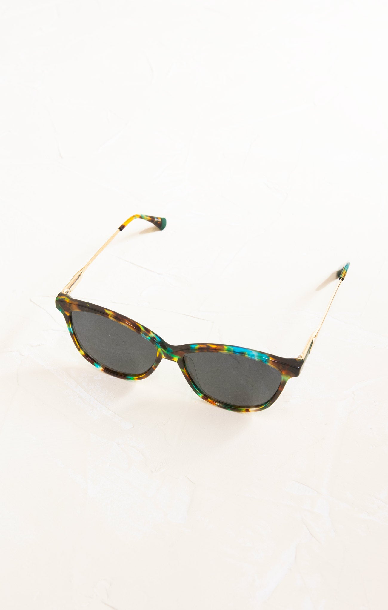 Sunglasses with tortoiseshell frame and dark lenses on a white background